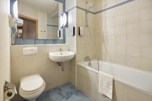 波兹南波兹南钟楼酒店的浴室配有卫生间、盥洗盆和浴缸。