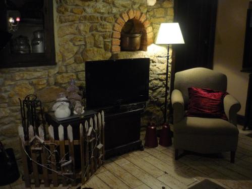 Nava卡萨乡村瑞图尔塔度假屋的客厅配有电视、椅子和台灯