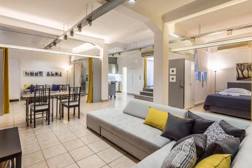 雅典Renovated Loft At the Center of Monastiraki的带沙发的客厅和用餐室