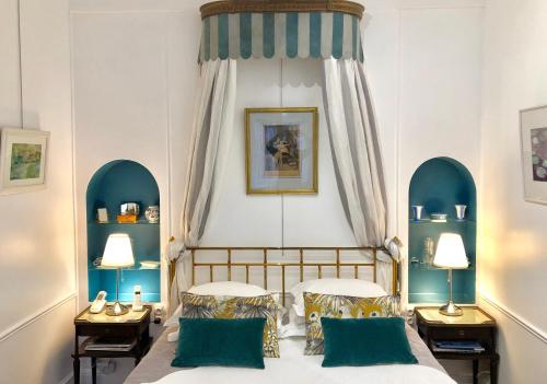 鲁昂VILLA la GLORIETTE的一间卧室配有两张床、两张桌子和两盏灯。