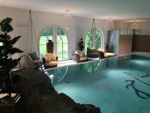巴特拉斯费伽戈霍夫格拉苏蒂罗莱夏朵精品酒店的一个带沙发和椅子的游泳池