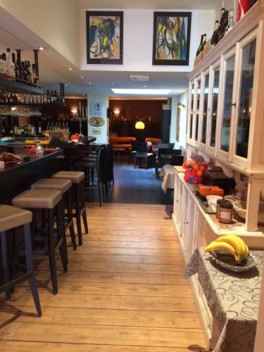米德尔克尔克B&B Geste d' Alice的一间带椅子的餐厅和一间在柜台上设有香蕉的酒吧