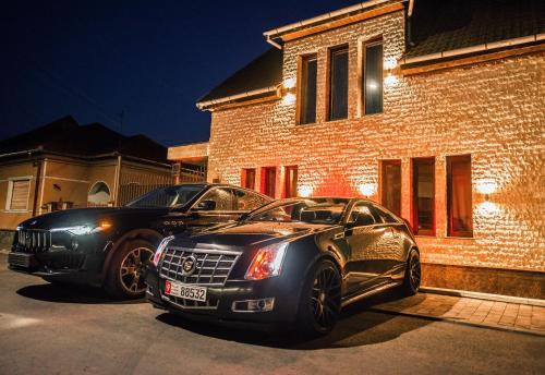 阿拉德H & V Residence - Diamond Bungalow Apartment的停在房子前面的一辆黑色汽车
