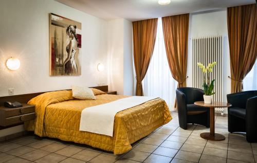洛迦诺黛尔安格洛酒店的酒店客房带一张床、一张桌子和椅子