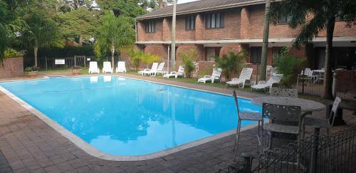 圣卢西亚Flamingo Holiday Flats的一个带桌椅的大型蓝色游泳池
