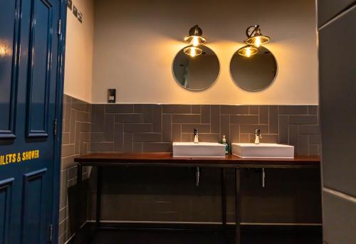 伦敦维多利亚白渡轮酒吧爱情旅舍的浴室设有2个水槽和2面镜子