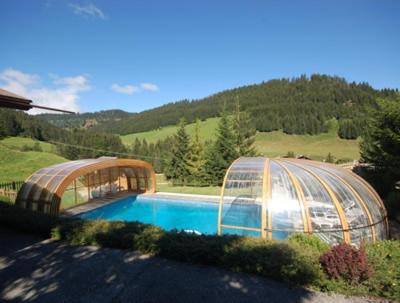 拉克吕萨Hôtel Chalet Alpage的温室和院子内的游泳池