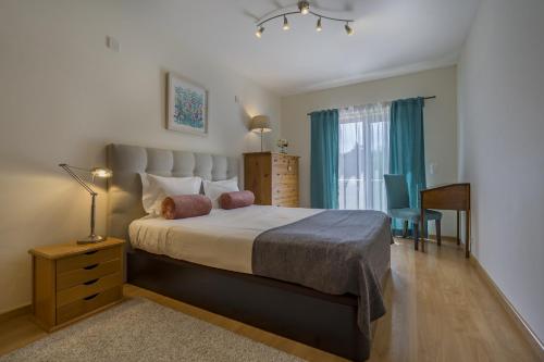 塞辛布拉Sesimbra Prime Apartment by be@home的卧室配有床、椅子和窗户。
