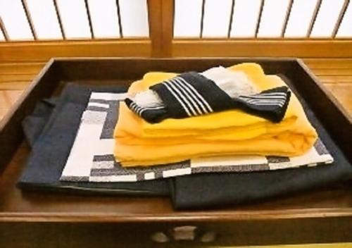 酒田市Wakaba Ryokan / Vacation STAY 29460的桌子上堆着的毛巾