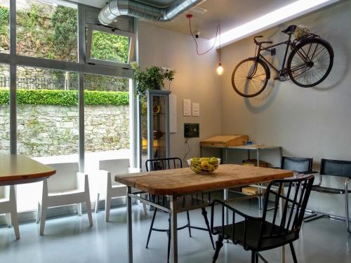 庞特维德拉Acolá Hostel的一间设有桌子的用餐室和墙上的自行车