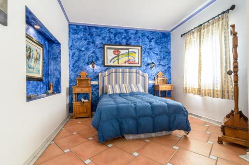 阿尔姆尼卡Habitaciones en Casa Céntrica con piscina的蓝色的卧室,配有床和蓝色的墙壁