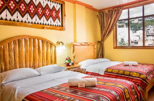奥塔瓦洛Hotel Santafe Inn的一间卧室设有两张床和窗户。