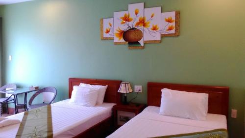 岘港塔比伊酒店的一间卧室配有两张床和一张带台灯的桌子