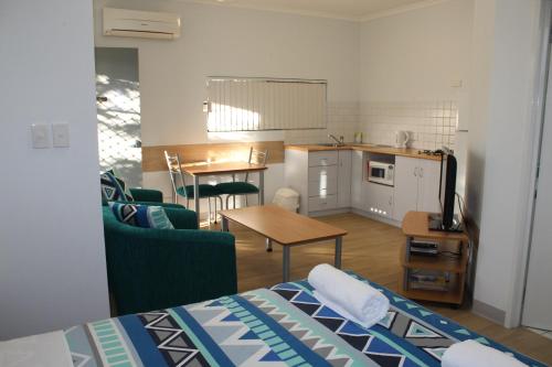 曼哲拉曼德拉海洋码头小屋酒店的一间带一张床的房间和一间带桌子的厨房