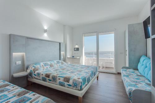 丽都迪萨维奥阿夏戈海滩酒店的一间带两张床的卧室,享有海景