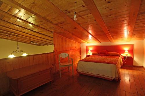 奥雷利亚纳拉维耶哈Casa Rural Casa de las Aves的一间卧室设有一张床和木制天花板