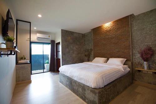 佛丕平查诺克度假村的一间卧室设有一张带砖墙的大床