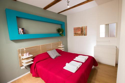 博洛尼亚Guasto Apartment的一间卧室配有红色的床和毛巾