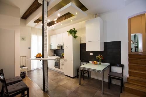 博洛尼亚Guasto Apartment的厨房配有白色橱柜和桌椅