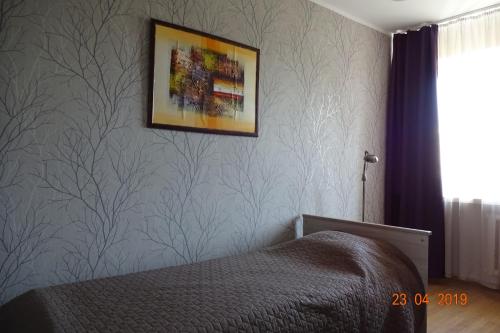 派尔努普伦策尔麦公寓的卧室配有一张床,墙上挂着一幅画