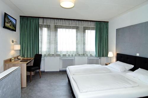 图特林根Hotel Café Schlack的酒店客房设有一张大床和一张书桌。