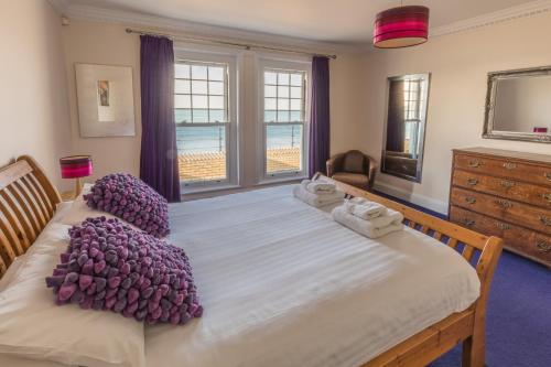 托特兰Promenade Apartment with own Beach Hut的一间卧室配有一张带紫色枕头的大床