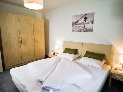 滨湖采尔AlpenParks Chalet & Apartment AreitXpress的卧室配有一张带两个枕头的大白色床