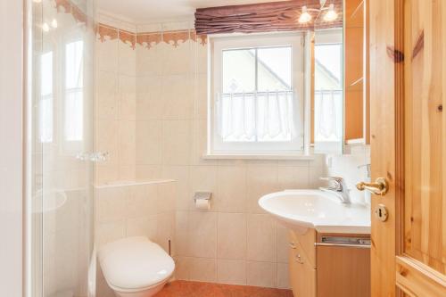 特拉森海德Ferienhaus Teuber的一间带水槽和卫生间的浴室以及窗户。