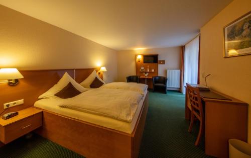 拜尔施泰因博夫雷登酒店的酒店客房设有一张大床和一张书桌。