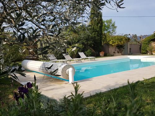 洛里La Parenthèse的一座房子旁带躺椅的游泳池