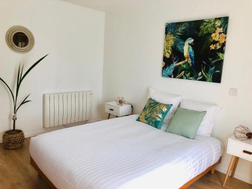 Boran-sur-OiseVILLA BIRDS的卧室配有白色的床和墙上的绘画作品