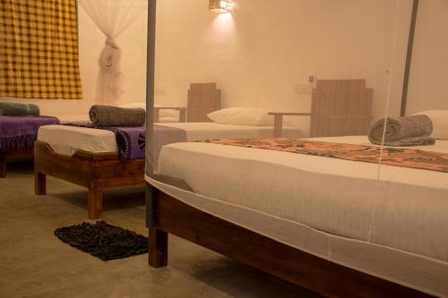 阿鲁甘湾Eagle Resort Arugambay的带两张床和镜子的客房