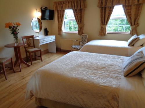 基拉尼红木酒店的酒店客房配有两张床和一张书桌