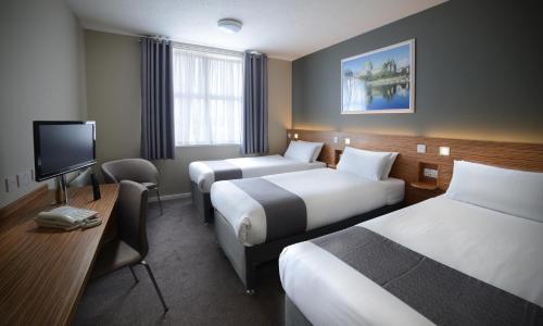 戈尔韦Travelodge Plus Galway的酒店客房设有两张床和一台平面电视。