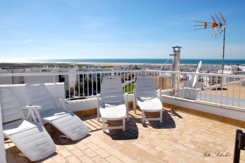 科尼尔-德拉弗龙特拉安达卢斯旅馆的海滩阳台上的一排白色椅子