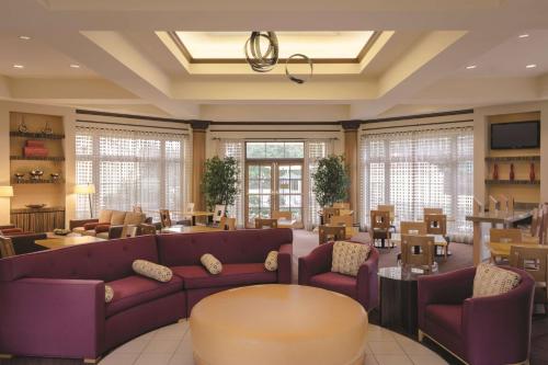 亚特兰大亚特兰大棒球场/拱廊拉金塔旅馆及套房酒店的客厅配有紫色的沙发、桌子和椅子