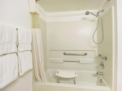 伍德伯恩伍德伯恩葡萄园套房酒店的浴室提供白色毛巾和淋浴。