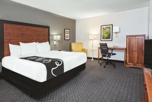 圣安东尼奥La Quinta Inn & Suites by Wyndham San Antonio Riverwalk的酒店客房设有一张大床和一张书桌。