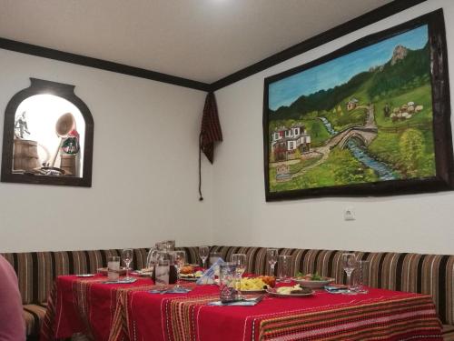 KozhariKuma Lissa Guest House的餐厅的一张桌子,上面有红色的桌布