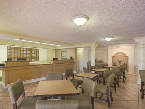 丘拉维斯塔圣地亚哥丘拉维斯塔拉金塔酒店的一间带桌椅的餐厅和一个等候区