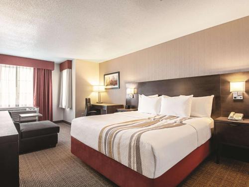 里士满温哥华机场拉昆塔酒店的酒店客房带一张大床和一把椅子