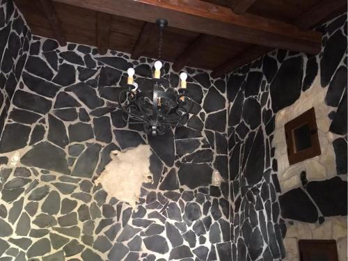 贝坦库里亚卡萨公主阿敏达酒店的吊灯挂在石墙上