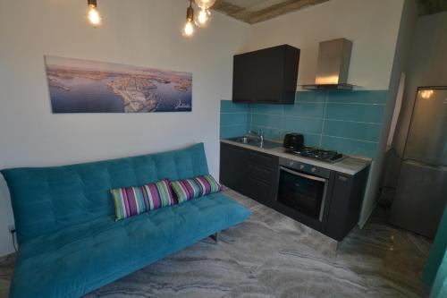 森格莱阿The Penthouse Flat-terrace&view的客厅设有蓝色沙发,厨房设有