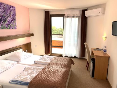 诺维·维诺多尔斯基Hotel Ruža的配有一张床、一张书桌和一扇窗户的酒店客房
