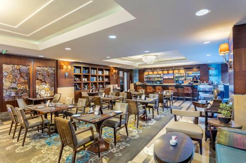 伊斯坦布尔泰坦尼克港口巴克科伊酒店的一间带桌椅的餐厅和一间酒吧