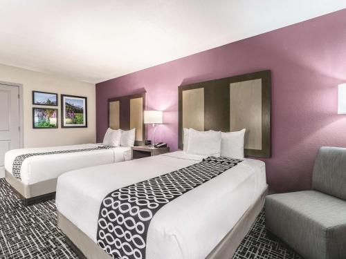 格伦伍德温泉La Quinta by Wyndham Glenwood Springs的酒店客房,配有两张床和椅子