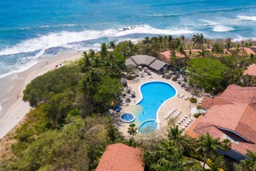 塔马林多Occidental Tamarindo - All Inclusive的享有度假胜地的空中景致,设有游泳池和海滩