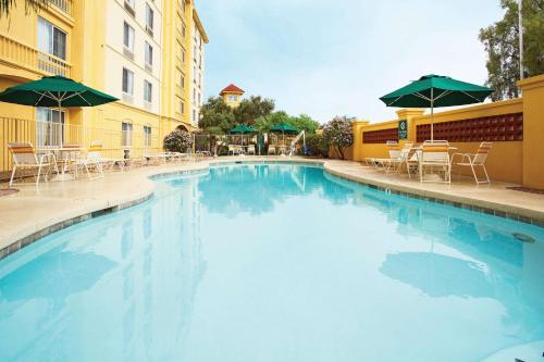 梅萨梅萨迷信泉拉金塔旅馆及套房酒店的一个带椅子和遮阳伞的大型游泳池