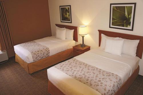 莱克兰La Quinta by Wyndham Lakeland East的酒店客房,设有两张床和一盏灯