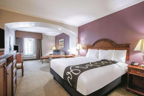 盖恩斯维尔盖恩斯维尔拉昆塔酒店及套房的酒店客房设有一张大床和一张书桌。